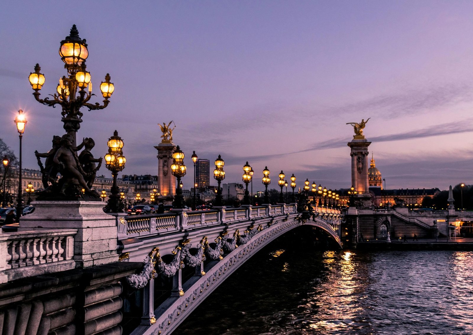 Lamps on the Pont Alexandre III at dusk, with the Seine below