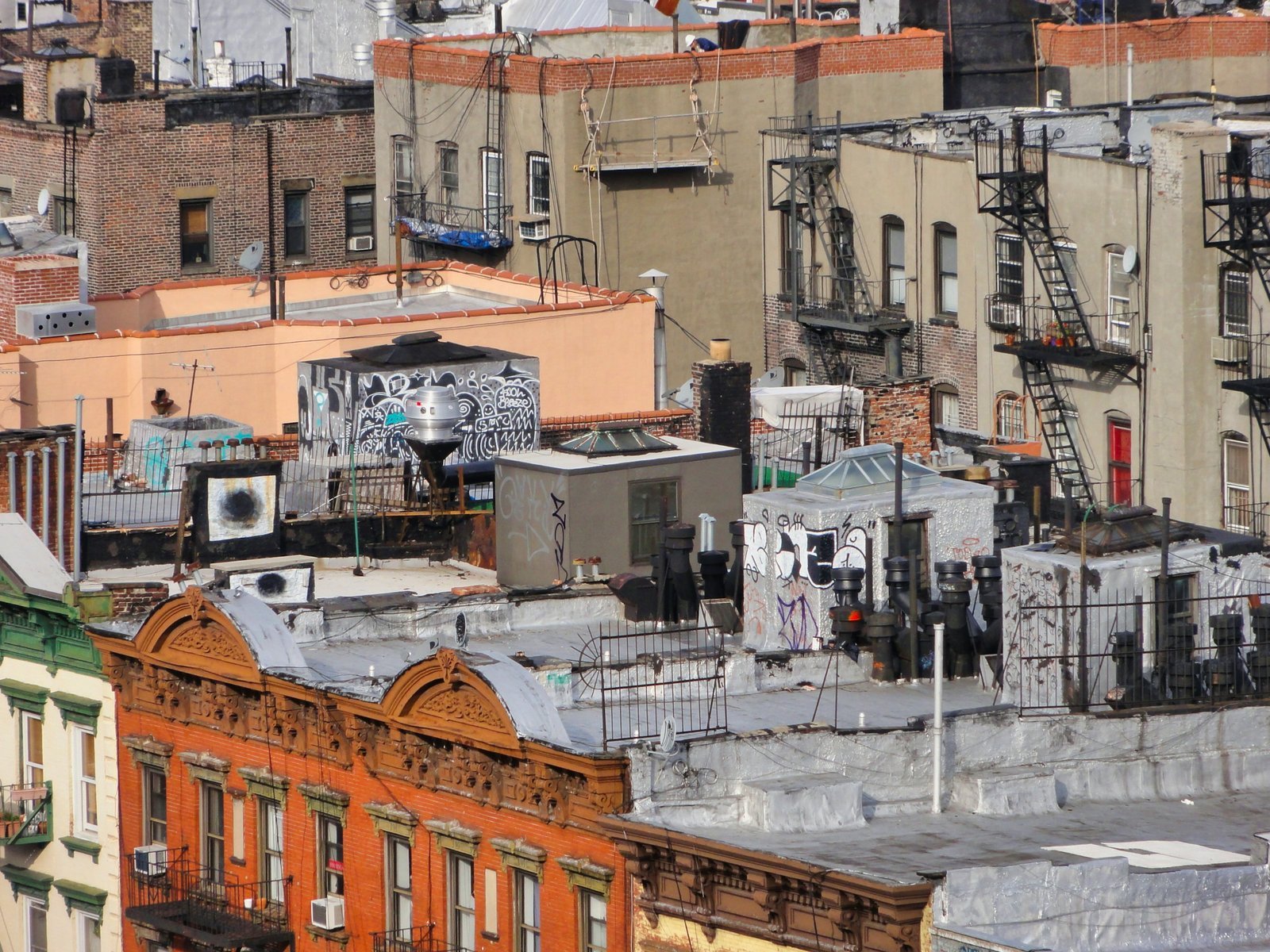 Tenement rooftops with fire escapes and water tanks